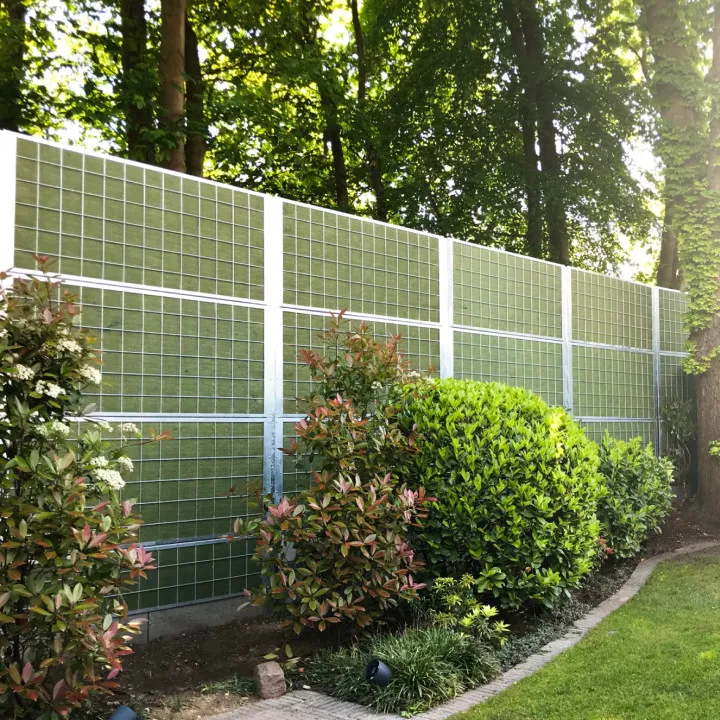 Noistop Steel geluidsscherm met PE-net afwerking en groene struiken in een residentiële omgeving